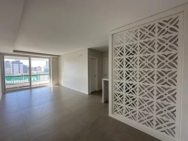 Sala de estar com piso de cerâmica e porta de vidro que dá para a vista externa.