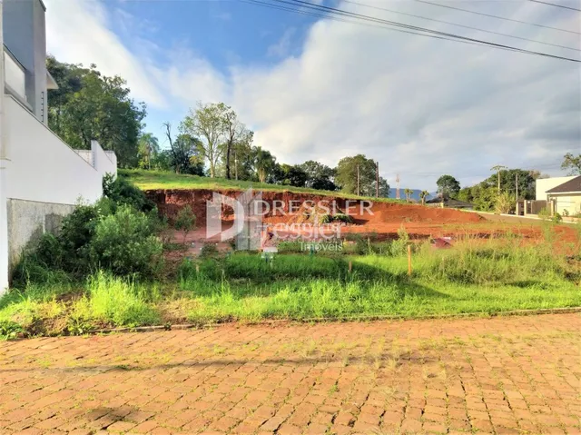 Vista da fachada de uma propriedade com área de terra em construção.