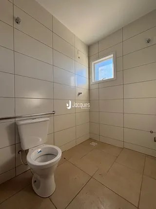 Banheiro com piso de cerâmica e paredes revestidas.