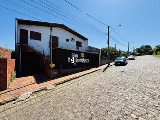 Fachada de uma residência em Lajeado, Brasil, com muro e área pavimentada na frente.