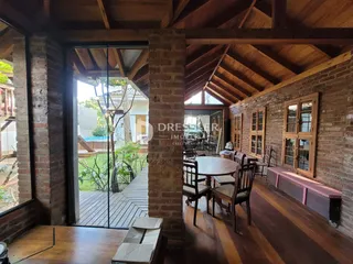 Sala de jantar com piso de madeira e vigas de madeira expostas em uma residência.