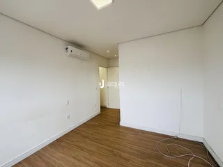 Hall de entrada com piso de madeira e paredes brancas.