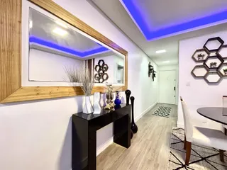 Hall de entrada com paredes brancas e detalhes em madeira clara.