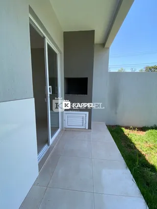 Fachada externa de uma residência com piso de cerâmica e área gramada.