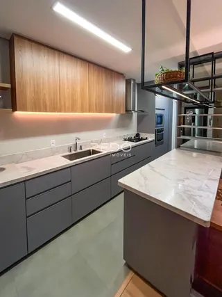 Vista da cozinha moderna com armários e bancadas em pedra.
