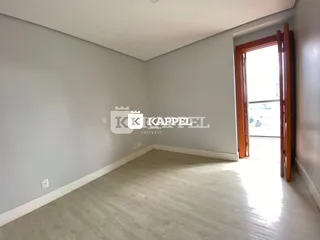 Foto de um cômodo interno com paredes cinzas e piso claro.