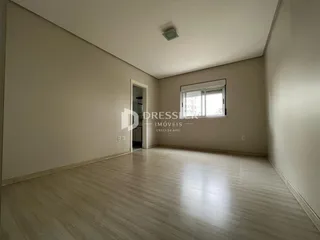 Vista interna de uma sala com piso de madeira clara.