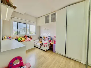 Quarto interno com decoração infantil e armários brancos.