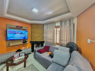 Sala de estar com sofá e televisão em ambiente com paredes laranjas.
