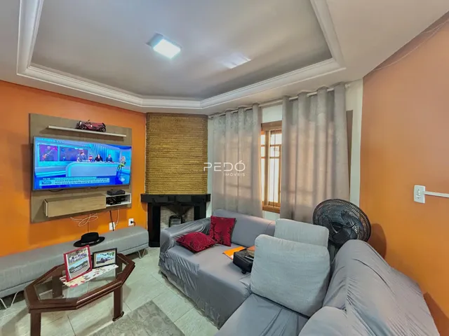 Sala de estar com sofá e televisão em ambiente com paredes laranjas.