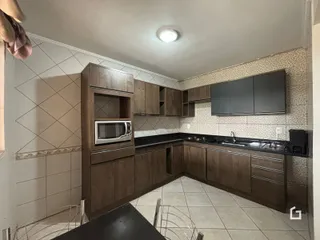 Foto de uma cozinha com armários de madeira e piso cerâmico.