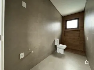 Hall de corredor com piso de cerâmica e paredes em tom neutro.