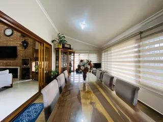 Vista de uma sala de jantar com mesa de madeira longa.