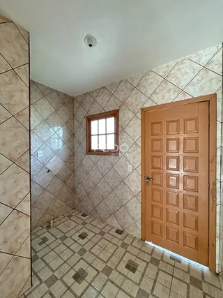 Um corredor com piso de cerâmica e paredes de azulejo.