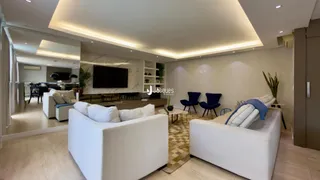 Sala de estar moderna com sofás brancos e decoração clara.
