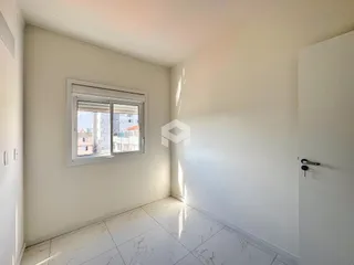 Ambiente interno de um cômodo com piso de porcelanato claro e janela.
