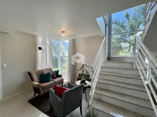 Sala de estar com vista para o exterior e escadaria.