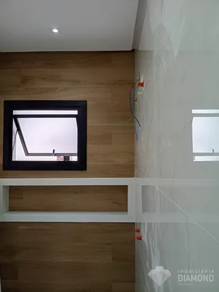Foto de um interior com piso de madeira e janela.