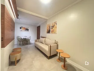 Sala de estar com sofá e mesa de jantar em ambiente claro.