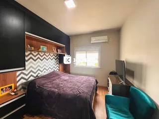 Quarto com cama grande, estantes de madeira e ar-condicionado instalado.