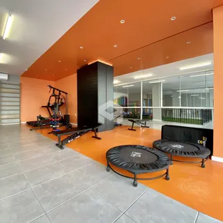 Espaço interno amplo com paredes laranjas e piso claro.
