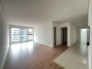 Sala de estar com piso de madeira clara e porta de vidro.