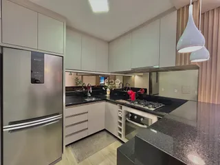 Uma cozinha moderna com armários e bancadas escuras.