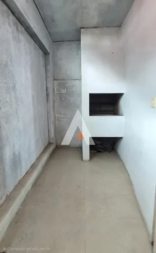 Corredor interno com paredes de concreto aparente.