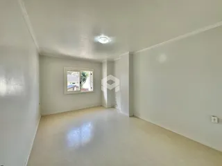 Vista interna de uma sala ampla com piso de madeira clara.