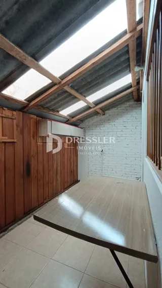 Interior com parede de tijolos brancos e teto de madeira exposto.