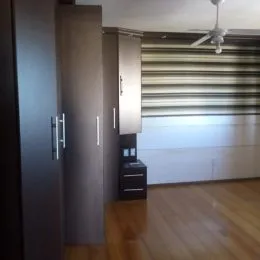 Vista interna de uma sala com armários e cortinas.