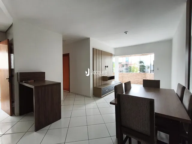Sala de estar e jantar com piso de cerâmica e móveis de madeira.