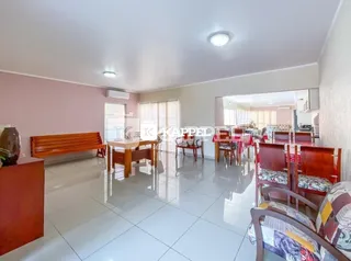 Ambiente interno com bancos de madeira e piso de cerâmica.