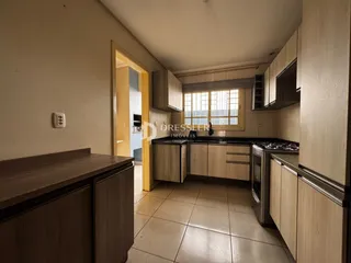 Cozinha com armários de madeira e piso de cerâmica.