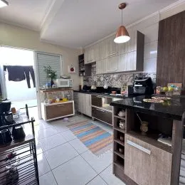 Foto interna de uma cozinha com armários brancos e piso de cerâmica.
