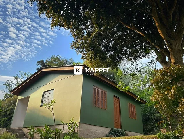 Fachada de uma casa em Lajeado, Brasil, com vegetação exuberante ao redor.