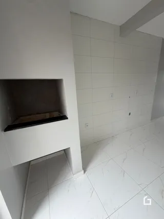 Vista interna de um corredor com piso de cerâmica branca.