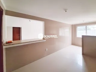 Ambiente interno com paredes claras e piso liso em uma sala de estar.