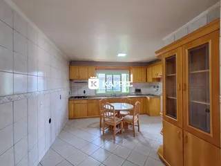 Foto de uma cozinha com armários de madeira e mesa de jantar em um imóvel.
