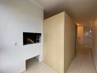 Uma parede branca com uma obra de arte está visível em um corredor interno.