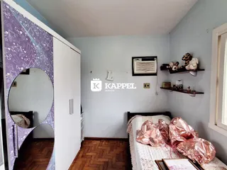 Quarto com cama e armário branco em um imóvel.