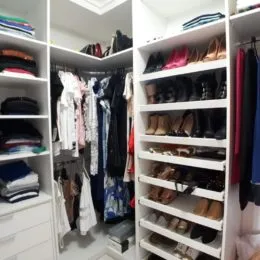 Armários e roupas penduradas preenchem o espaço de armazenamento interno.
