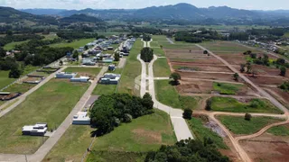 Vista aérea de uma propriedade rural com campos e vegetação ao redor.