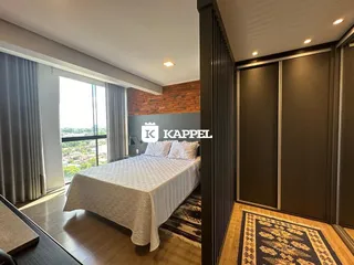 Quarto com cama grande e janela com vista para a paisagem.