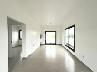 Hall de entrada com piso de cerâmica e grandes janelas.