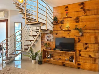 Sala de estar com parede de madeira e escadaria moderna.