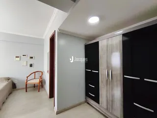 Quarto com armário planejado e paredes cinzas em um imóvel no Brasil.