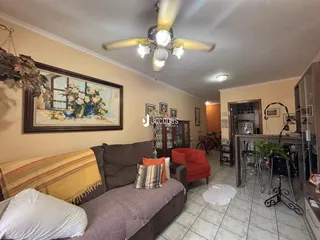 Sala de estar com sofá e pintura na parede em uma residência.