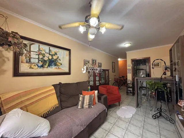 Sala de estar com sofá e pintura na parede em uma residência.