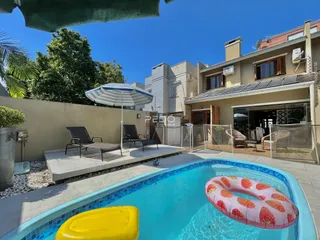 Foto de uma área de piscina externa com espreguiçadeiras em uma residência.